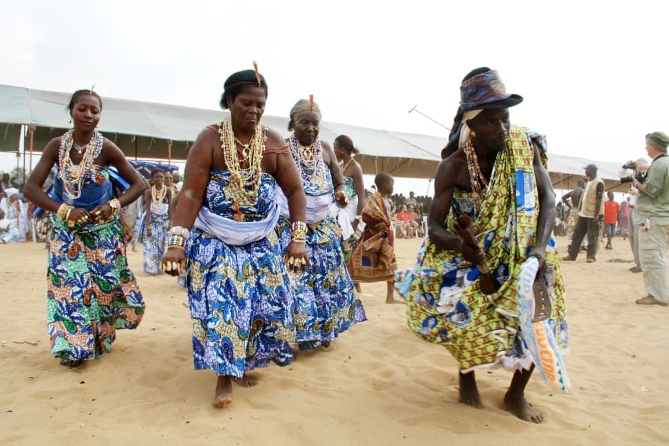 Women dancers in blue wraps and bead necklaces on the beach